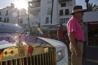 Varios turistas al lado de un Rolls Royce en Puerto Banús