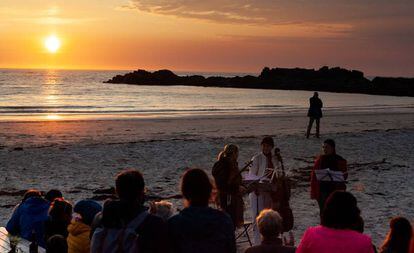 Tres miembros del Cuarteto Sonoro tocan en la medianoche del martes en la playa de Gimsøy.
