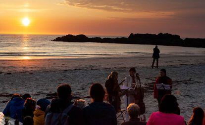 Tres miembros del Cuarteto Sonoro tocan en la medianoche del martes en la playa de Gimsøy. 