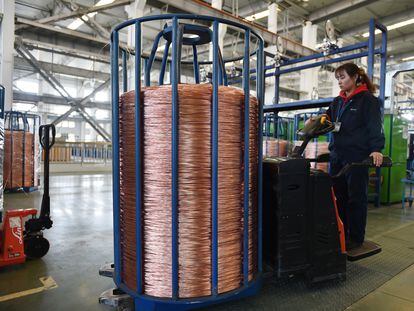 Una empleada transporta una bobina de cable de cobre en la provincia china de Jiangsu.