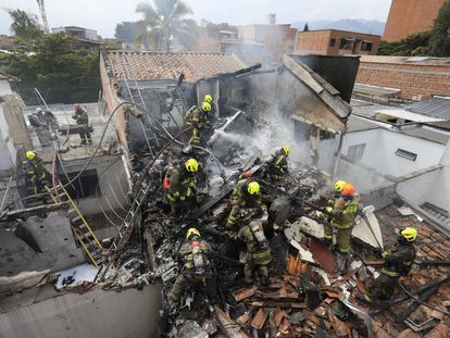 Bomberos trabajan en las casas donde se estrelló la avioneta en Medellín.
