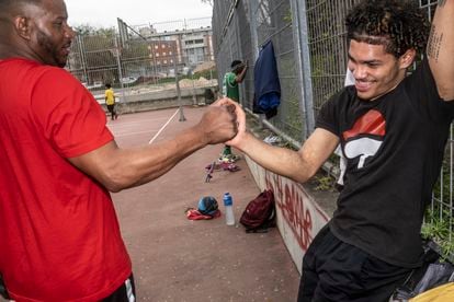 Dos jóvenes dominicanos se felicitan, después de jugar un partido de baloncesto en una cancha del distrito de Villaverde, en Madrid.


