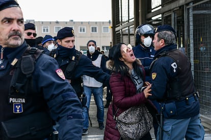 Agentes de policía sujetan a la pariente de un recluso que protesta ante una cárcel en Módena (Italia).