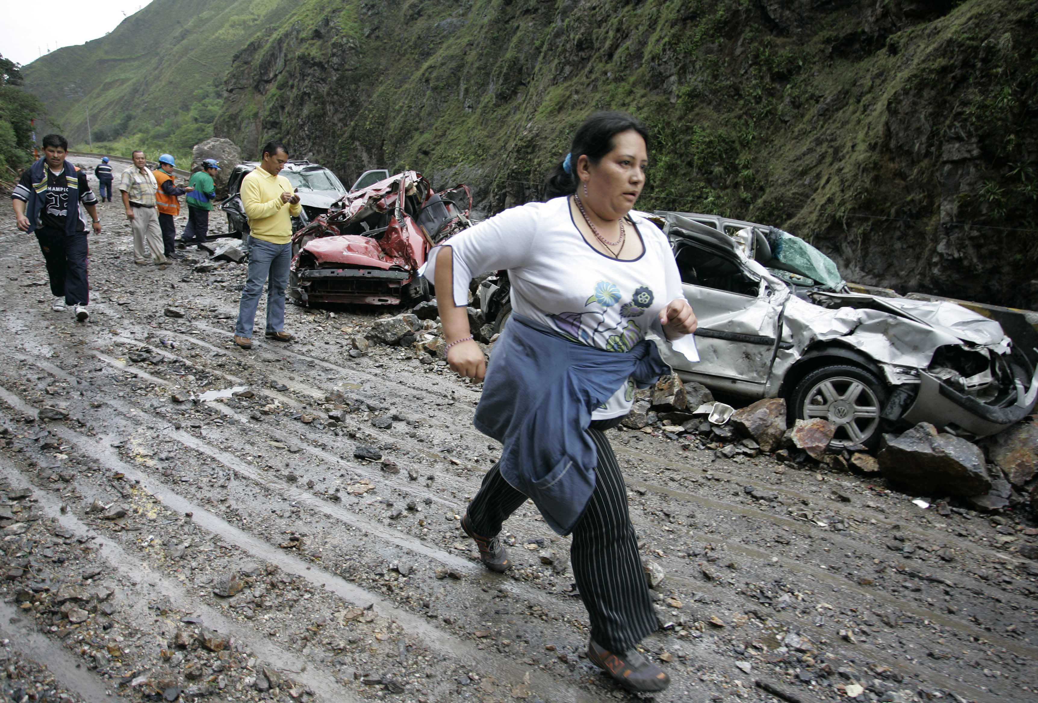 Una mujer pasa junto a unos carros dañados por un terremoto en Quetame, al sureste de Bogotá.
