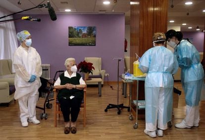 Araceli, la residente de mayor edad, sentada en una silla, momentos antes de recibir el primer pinchazo en España de manos de una enfermera.