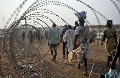 Decenas de desplazados caminan junto a la base de la ONU en Juba, Sud&aacute;n del Sur, el 16 de enero.