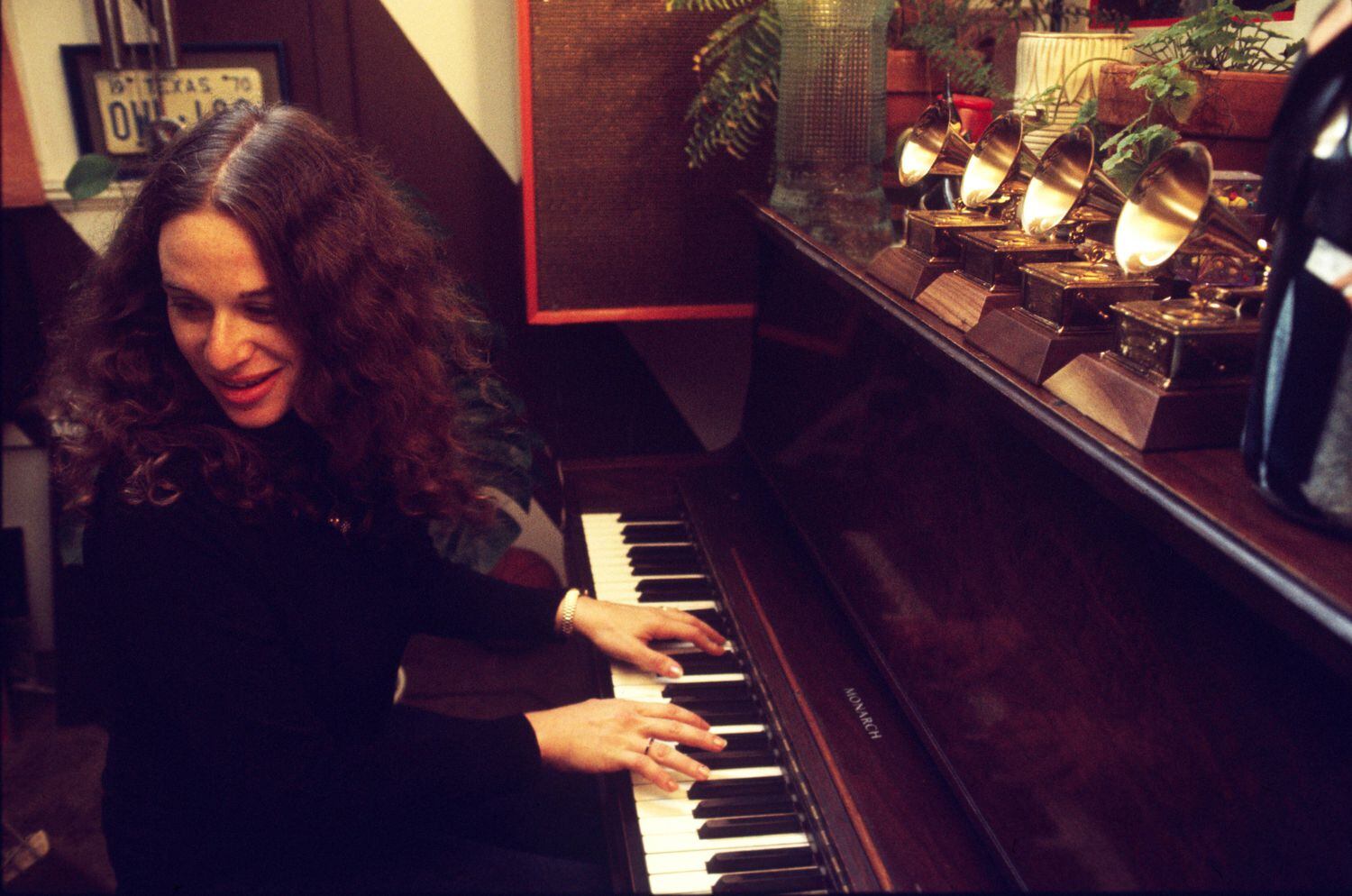 Carole King tocando el piano en casa del productor Lou Adler en marzo de 1971 en Los Angeles, ante los cuatro Grammys que acababa de ganar por 'Tapestry'.