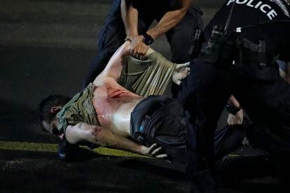 Un manifestante herido es detenido por la policía durante una protesta en Tel Aviv, este lunes.