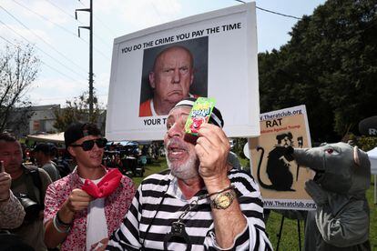 Un grupo de manifestantes anti-Trump sostienen pancartas en las que se pide la detención del ex mandatario. 