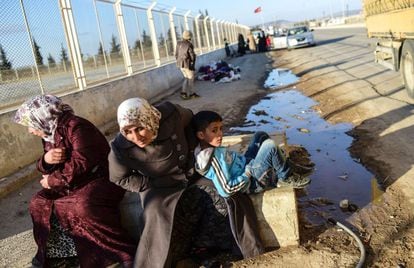 Dos refugiadas sirias y un niño esperan cruzar el paso fronterizo turco de Öncüpinar, cerca de Kilis, para volver a su país.