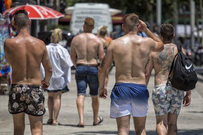 Un grupo de turistas sin camiseta en las inmediaciones de la playa la Barceloneta.