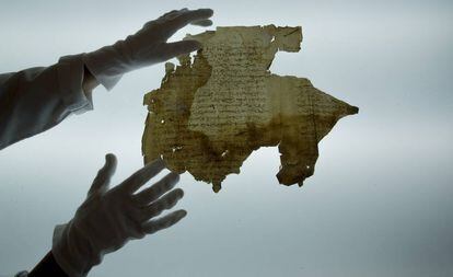 La restauradora Mónica Santos, del IAPH, muestra el único fragmento original que queda del testamento de Magallanes.