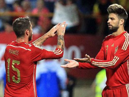 Gerard Piqué y Sergio Ramos chocan las manos en uno de los partidos que compartieron en la selección española.