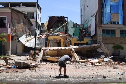 Un hombre saca una fotografía de un edificio derrumbado en Machala (Ecuador), este sábado.