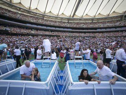 Dos mujeres son bautizadas en un evento organizado por los Testigos de Jehová.