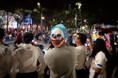 Un grupo de ciudadanos observa el paso de los motociclistas durante la rodada nocturna por Paseo de la Reforma, en Ciudad de México, el 30 de octubre de 2022.