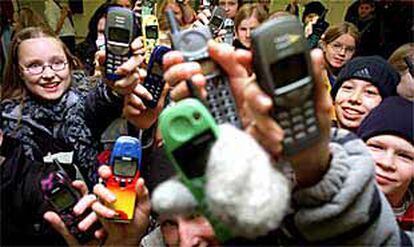 Un grupo de niños muestra diferentes modelos de móviles.