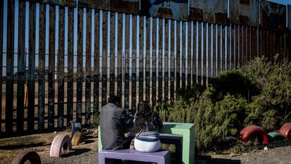 Una pareja de mexicanos pasa la tarde frente al muro fronterizo de Tijuana.