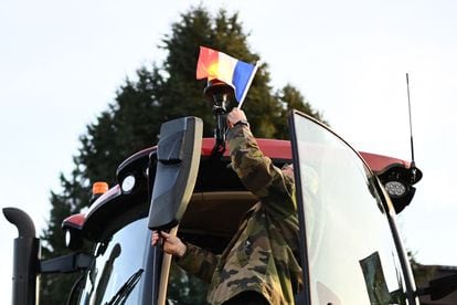 Un agricultor francés coloca una bandera francesa en su tractor mientras un convoy se prepara para partir de Boe, cerca de Agen, en el suroeste de Francia, tras los llamamientos del sindicato CR47 (Coordinación rural 47) para bloquear el mercado de Rungis, el mercado de mayoristas más grande del mundo, cerca de París.