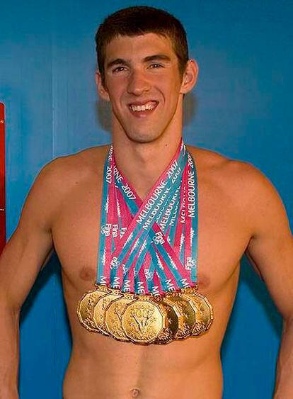 Michael Phelps exhibe con satisfacción todas sus medallas.