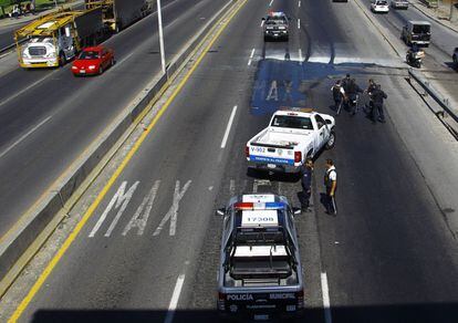 Los miembros de la policía local en la avenida Gómez Morín , en la ciudad de Guadalajara. Más de una docena de vehículos fueron incendiados el viernes en la segunda ciudad más grande de México, después de que una banda de narcotraficantes se enfrentara a las autoridades.