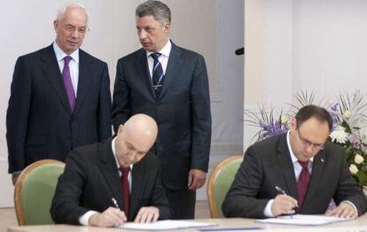El primer ministro de Ucrania, Mykola Azarov y el ministro de energía, Yuri Boiko, conversan de pie mientras Vladislav Kaskiv, responsable de la agencia de inversiones estatal firma un acuerdo con Jordi Sardà Bonvehí, sentado en primer término a la izquierda, supuesto representante de Gas Natural