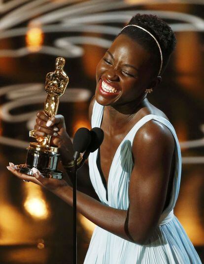 Lupita Nyong'o saluda con el Oscar que ha ganado como mejor actriz de reparto por la película '12 años de esclavitud'.