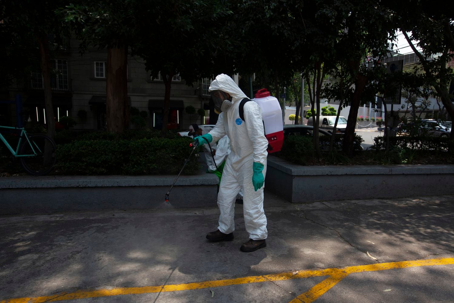 Un trabajador rocía   un químico conocido como fenol para sanitizar la avenida Campos Elíseos  