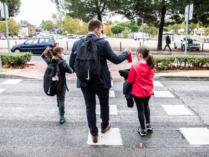 Un padre lleva a sus hijas al colegio.