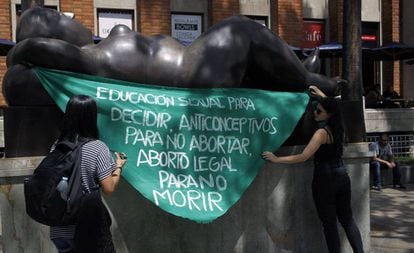 Dos mujeres protestan a favor del aborto en una escultura del artista Fernando Botero, en Medellín (Colombia).