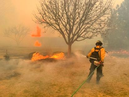 Una foto facilitada por el Departamento de Bomberos de Flower Mound (Texas) muestra a bomberos ayudando a contener un incendio forestal en la región del Panhandle de Texas.