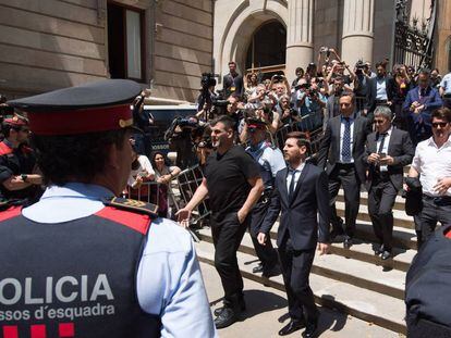 El jugador del FC Barcelona Lionel Messi (c) y su padre, Jorge Horacio Messi (detrás), sale de la Audiencia de Barcelona tras declarar en la tercera jornada del juicio.