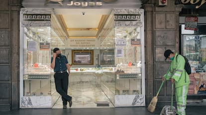 Un trabajador municipal barre la acera junto a una joyería en Ciudad de México, en abril de este año.