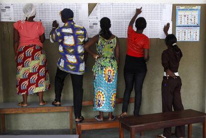 Votantes congoleños buscan sus nombres en el censo en un colegio electoral de Kinshasa.