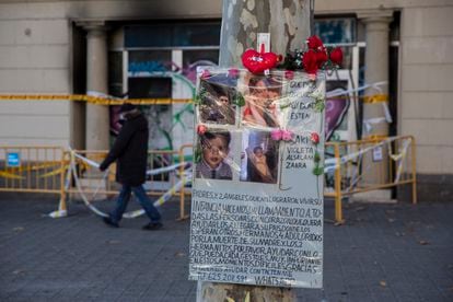 Flores y un cartel con fotos en recuerdo de las víctimas del incendio del pasado martes en un local en la plaza de Tetuán de Barcelona.