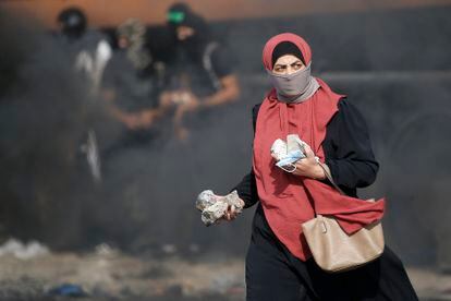 Una mujer con piedras en la mano durante un choque entre palestinos y fuerzas israelíes en la entrada norte a Ramala (Cisjordania), el viernes.