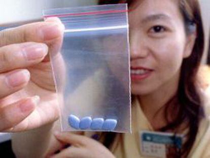 Una mujer muestra pastillas de Viagra