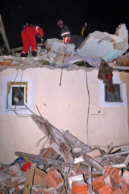 Miembros de los equipos de rescate examinan un edificio dañado en Kraljevo.