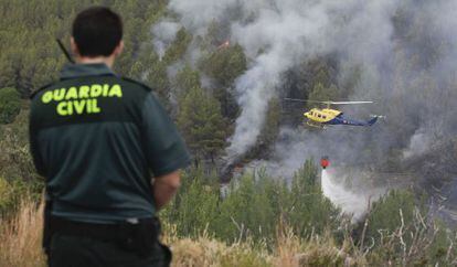 Un helicóptero descarga agua sobre el bosque en el término de Bejís.