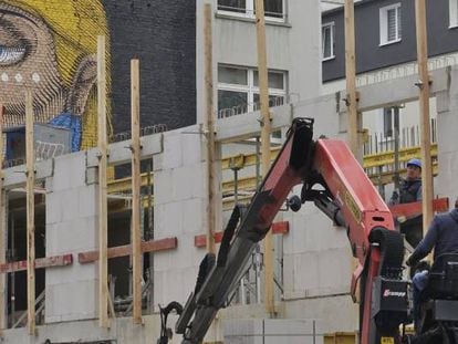 Dos operadores realizan tareas de construcción para un hotel cerca de la estación central de ferrocarril de Fráncfort (Alemania).
