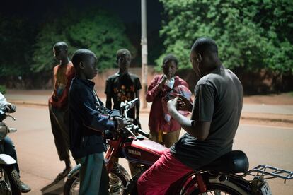 Theophile Palenfo, educador social, habla con un grupo de niños que se ha encontrado en la calle durante la vuelta de reconocimiento que hace tres días a la semana para identificar los niños en situación de calle en la ciudad de Bobo-Dioulasso, en Burkina Faso.