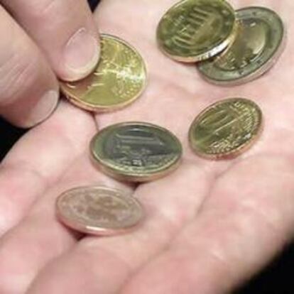 Una persona muestra unas monedas en la mano