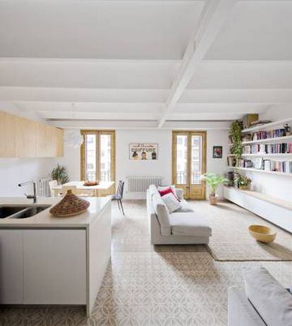 En esta vivienda de Barcelona, dise&ntilde;o de A&amp;EB, se utilizan los muebles altos de la cocina como espacio de almacenaje del sal&oacute;n.