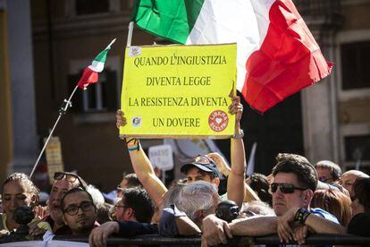 Un activista muestra la pancarta &quot;Cuando la injusticia se convierte en ley, la resistencia se convierte en un deber&quot; durante una manifestaci&oacute;n, convocada por el Movimiento 5 Estrellas este mi&eacute;rcoles. 