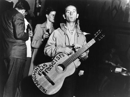 Retrato del músico de folk estadounidense Woody Guthrie con su guitarra en la que estaba escrito 'Esta máquina mata fascistas'.