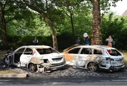 Varios periodistas cerca de coches quemados durante las protestas en Hamburgo.