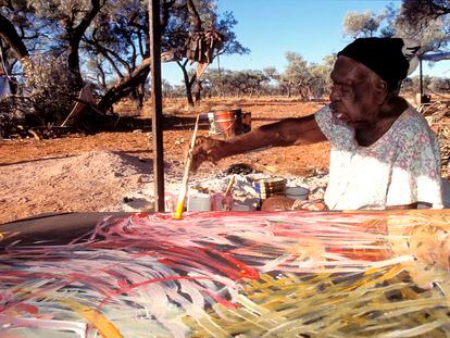La artista Emily Kame Kngwarreye pinta uno de sus lienzos en la comunidad Utopia, en la Australia Central