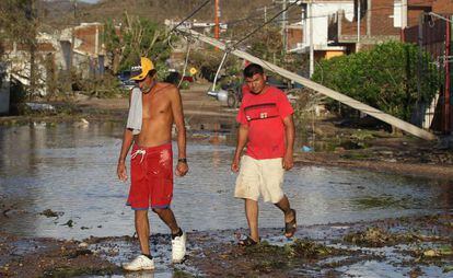 Dos hombres caminan por una calle tras el paso del hurac&aacute;n Patricia en el municipio de Francisco Villa, en el estado mexicano de Jalisco.