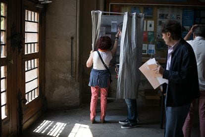 Una pareja prepara sus votos en el colegio electoral de plaza Universidad de Barcelona.