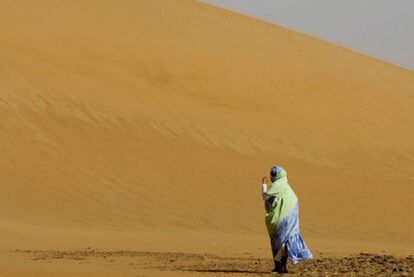 Una mujer camina entre las dunas del desierto del Sáhara argelino.